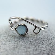 A silver and aquamarine ring with a twist and open spiral design. It's adjustable and perfect as a gift if you're not quite sure of the size you need. The shank is twisted from one wire and in the loop at the end is nestled a round faceted aquamarine bead. This version is milky which highlights the colour wonderfully and reminds me of frozen lakes and ice skating. Versions with a clear aquamarine and with moss aquamarine are also available in my shop. The opposite end from the gem is shaped into Adjustable Aquamarine Round Jewelry, Adjustable Round Aquamarine Jewelry, Adjustable Aquamarine Bracelet, Adjustable Aquamarine Jewelry, Adjustable Aquamarine Gemstone Rings, Adjustable Aquamarine Jewelry As Gift, Adjustable Light Blue Sterling Silver Rings, Unique Silver Aquamarine Jewelry, Viking Jewellery