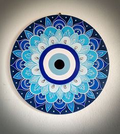 a blue and white plate with an evil eye in the center, on a wall