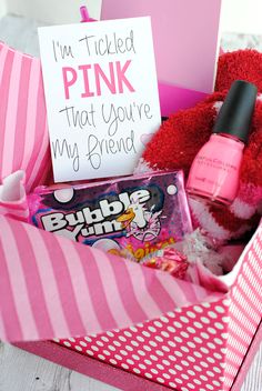 a pink gift box filled with candy and a sign that says i'm tickled pink