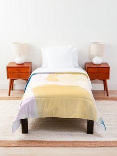 a bed with two nightstands next to it and a white wall in the background