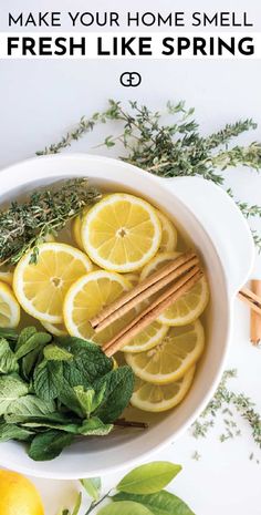 a bowl filled with lemons, herbs and cinnamon sticks on top of a white table