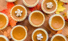 several pies are arranged on a table with autumn leaves