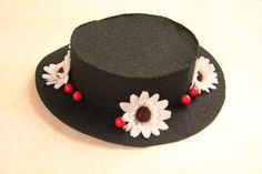 a black hat with white and red flowers on the brimmed top, sitting on a table