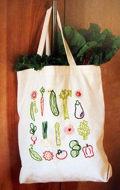 a tote bag with vegetables on it hanging from a door