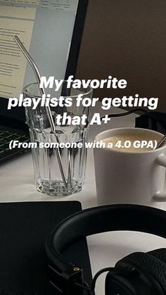 a laptop computer sitting on top of a desk next to a cup of coffee and headphones