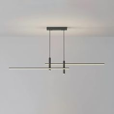 three lights hanging from the ceiling in a room with white walls and grey flooring