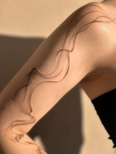 a woman's arm with lines drawn on it and her hair blowing in the wind