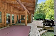 a large wooden porch with lots of windows and wood sidings on the side of it