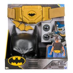 the batman costume is in its box with accessories on it's chest and head