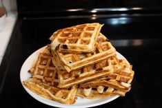 a white plate topped with waffles on top of a stove