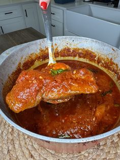 a large pan filled with meat covered in sauce