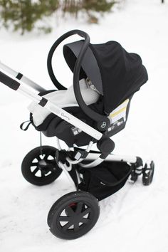 a baby stroller sitting in the snow