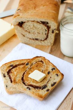 a loaf of bread with butter and chocolate swirl on it next to a glass of milk