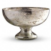 a silver bowl sitting on top of a white table