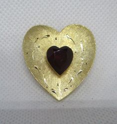 *Any dark areas or dark spots are in the pictures only not on the brooch.* Never worn vintage 1970s JJ Jonette etched gold tone metal heart large red rhinestone heart brooch.  Brooch Length 1 & 3/8 inches. Brooch Width 1 & 1/4 inches. Rhinestone Heart Length 1/2 inch. Rhinestone Heart Width 7/16 inch. I offer multiple item order shipping discounts. Handwritten Gifts, Bethlehem Pa, Heart Rhinestone, Brooch Bouquets, Heart Brooch, Metal Heart, Plastic Jewelry, Rhinestone Heart, Art Deco Earrings