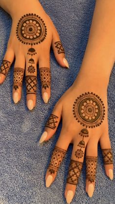 two hands with henna tattoos on them