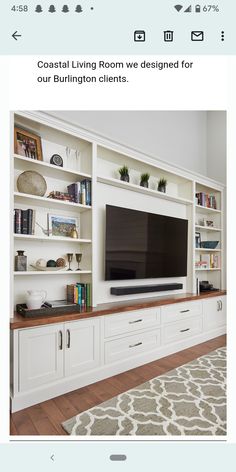 a living room with white bookcases and a flat screen tv on the wall