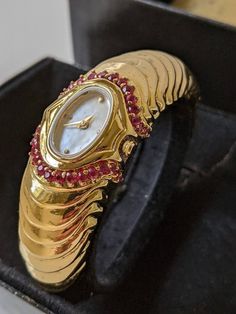 Vintage Franklin Mint Gold-Tone Art Deco Ruby Watch w/Mother of Pearl Dial RUNS! This watch is new but the back has scratches from trying to replace the battery.  Plastic cover on the back still attached. Stand of the watch (part of the box diplay is loose ). New battery installed. Comes with original paperwork and box. . Luxury Art Deco Jewelry And Watches For Formal Occasions, Luxury Rectangular Art Deco Watches, Tone Art, Art Deco Watch, Mint Gold, Franklin Mint, Plastic Cover, Women Wrist Watch, Wrist Watches