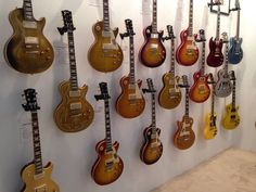 guitars are lined up on the wall for display