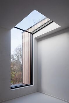 an empty room with a large window and skylight