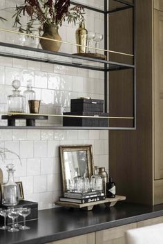 a kitchen counter topped with shelves filled with bottles and glasses