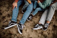 three people sitting on the ground with their legs crossed