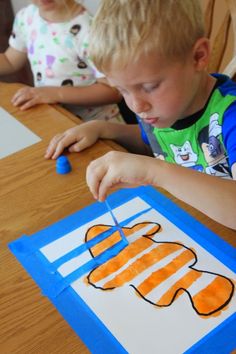 two children sitting at a table making crafts