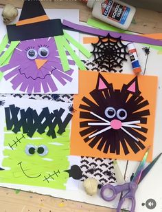 paper cut out of cats and spider webs on a table with crafting supplies