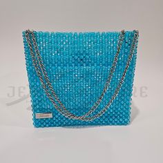 This greenish-blue iridescent box-shaped finely assembled beaded bag is crafted from high quality iridescent round bead with shimmering finish. It features an adjustable silver-tone chain-link strap that adds a touch of shine and versatile carry option with an inner flap closure for a unique look. * Greenish-blue color * Iridescent shimmering finish * Silver-tone hardware * Adjustable strap: 9"- 16" * 8.75"W X 8.25"H X 3.5"D * 6.25" inner height * Inner magnetic snap * Wipe clean * Dust bag incl Greenish Blue, Beaded Bags, Blue Bags, Chain Link, Round Beads, Cleaning Wipes, Silver Tone, Blue Color, Hand Weaving