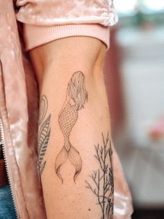 a woman's leg with a tattoo on it and a fish in the water