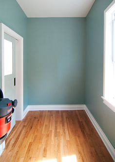 an empty room with hard wood floors and blue walls