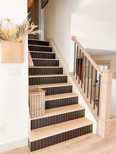 there is a basket on the stairs next to the carpeted stair case in this house