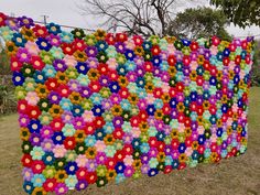 a large multicolored wall hanging in the grass