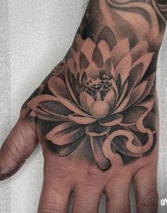 a person's hand with a tattoo on it and a flower in the middle