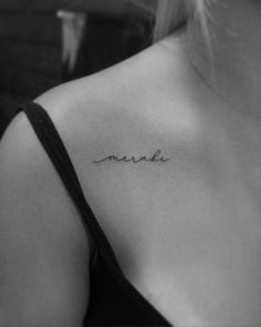 a woman's upper back tattoo with the word made in cursive writing