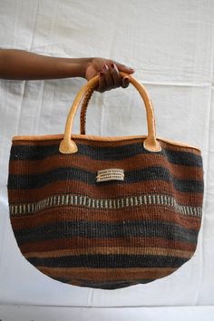 Elegant sisal bag with leather handles/ Handmade woven bag/ Kiondo bag/ African ethnic bag/ Market bag/ African Shopping bag / Tote bag. The bag is handmade from baobab fiber in Kenya and finished up with tough leather handles. The stripped patterns are made by mixing different dyed baobab fibers. This lovely basket can be used as a storage basket,market basket, shopping basket, weekend basket bag, beach bag.It could also be a Holiday gift,, anniversary gift to Moms,Christmas gift, gift to daugh Sisal Bags, African Bag, Ethnic Bag, Market Basket, Sac Week End, Christmas Mom, Basket Bag, Shopping Basket, Christmas Gifts For Mom