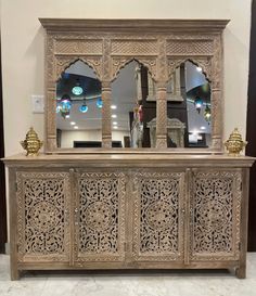 an ornate wooden cabinet with mirrors on top