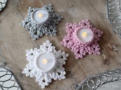 three crocheted candles sitting on top of a wooden table