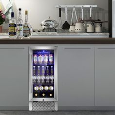 an image of a beverage cooler in the middle of a kitchen counter with bottles on it