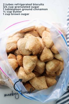 a plastic bag filled with dog biscuits on top of a white tablecloth next to a blue and white striped napkin