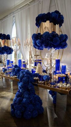 a table with blue flowers and candles on it