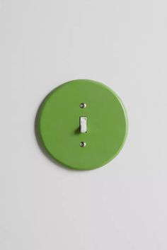 a green button with two white buttons on the front and one red button on the back