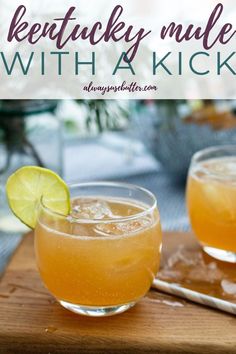 two glasses filled with drinks sitting on top of a wooden cutting board