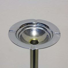 a metal object on a white wall with a round base and two circular knobs