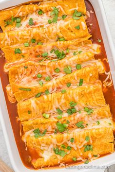 an enchilada casserole in a white dish with green garnish