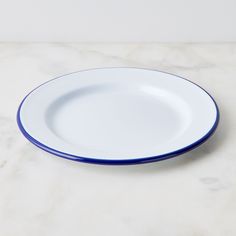 a white and blue plate sitting on top of a marble countertop next to a wall