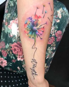 a woman's arm with a dandelion tattoo on it