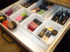 the drawers are organized with makeup and other beauty products on it's trays