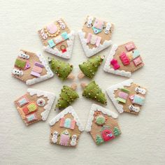 a group of small christmas ornaments made out of felt on top of a white surface