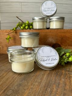 three jars of candles sitting on top of a wooden table